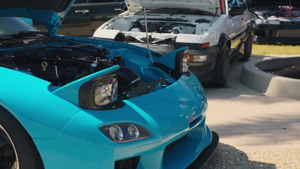 Teal sports car with the hood up