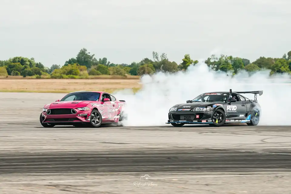 Pink and black drift cars in tandem