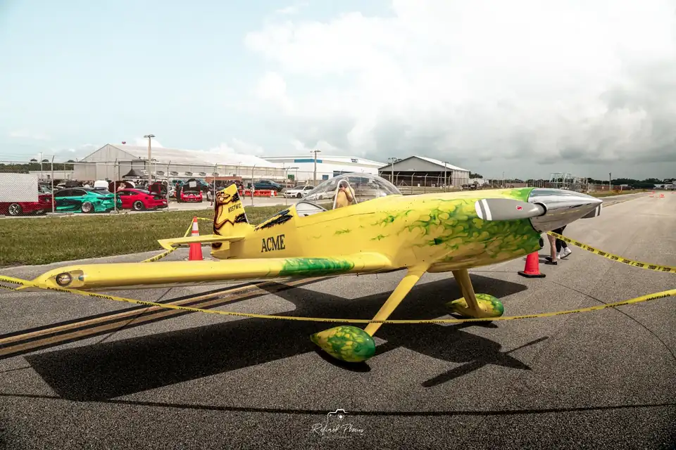Aerobatic plane parked on the grass beside the show