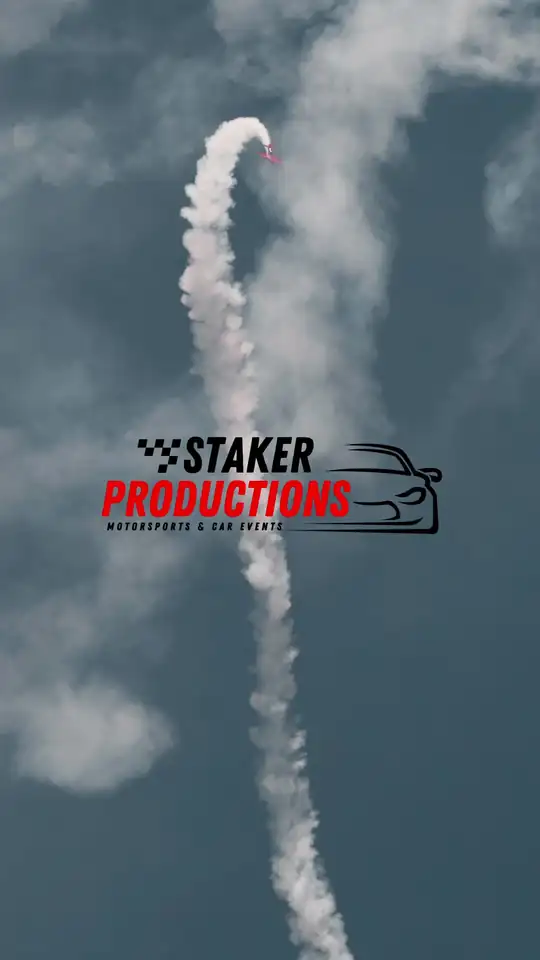Aerobatic plane trailing smoke over the show