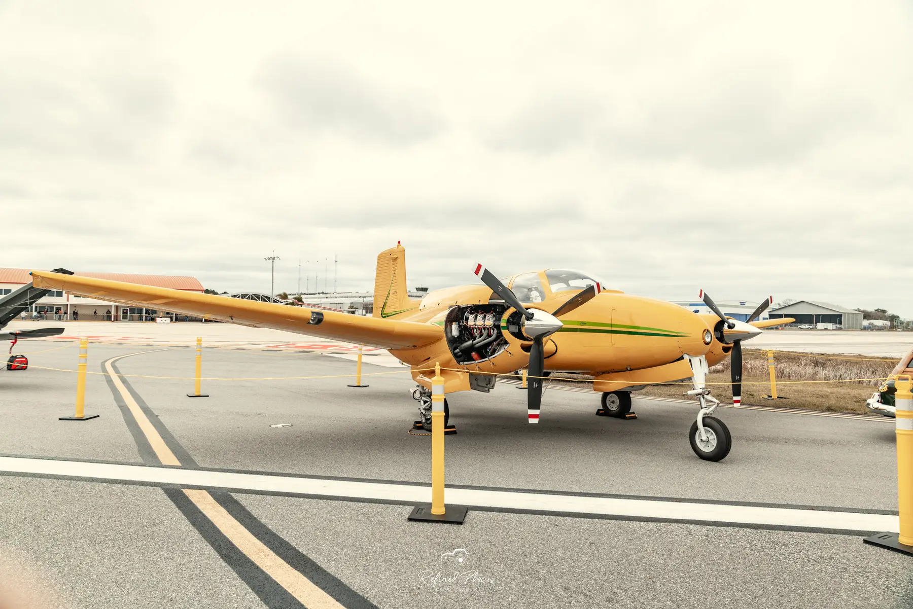 Yellow twin-engine plane on the runway at Wings N&rsquo; Wheels