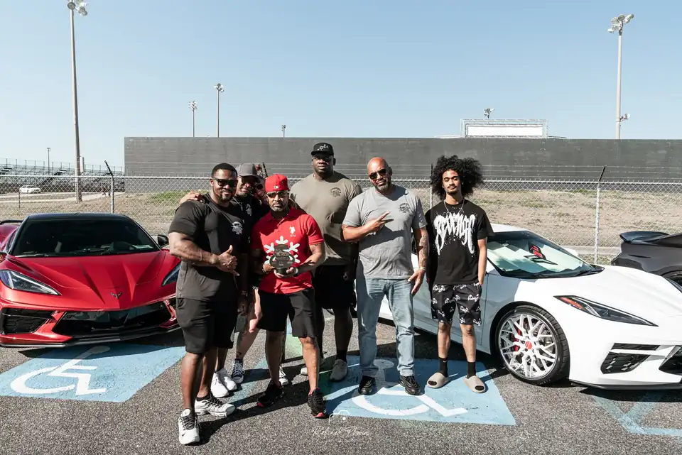Drivers posing with two Corvettes