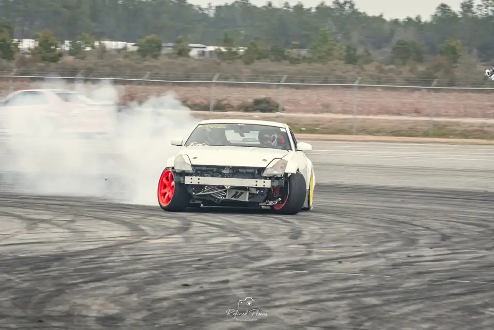 White drift car mid-slide