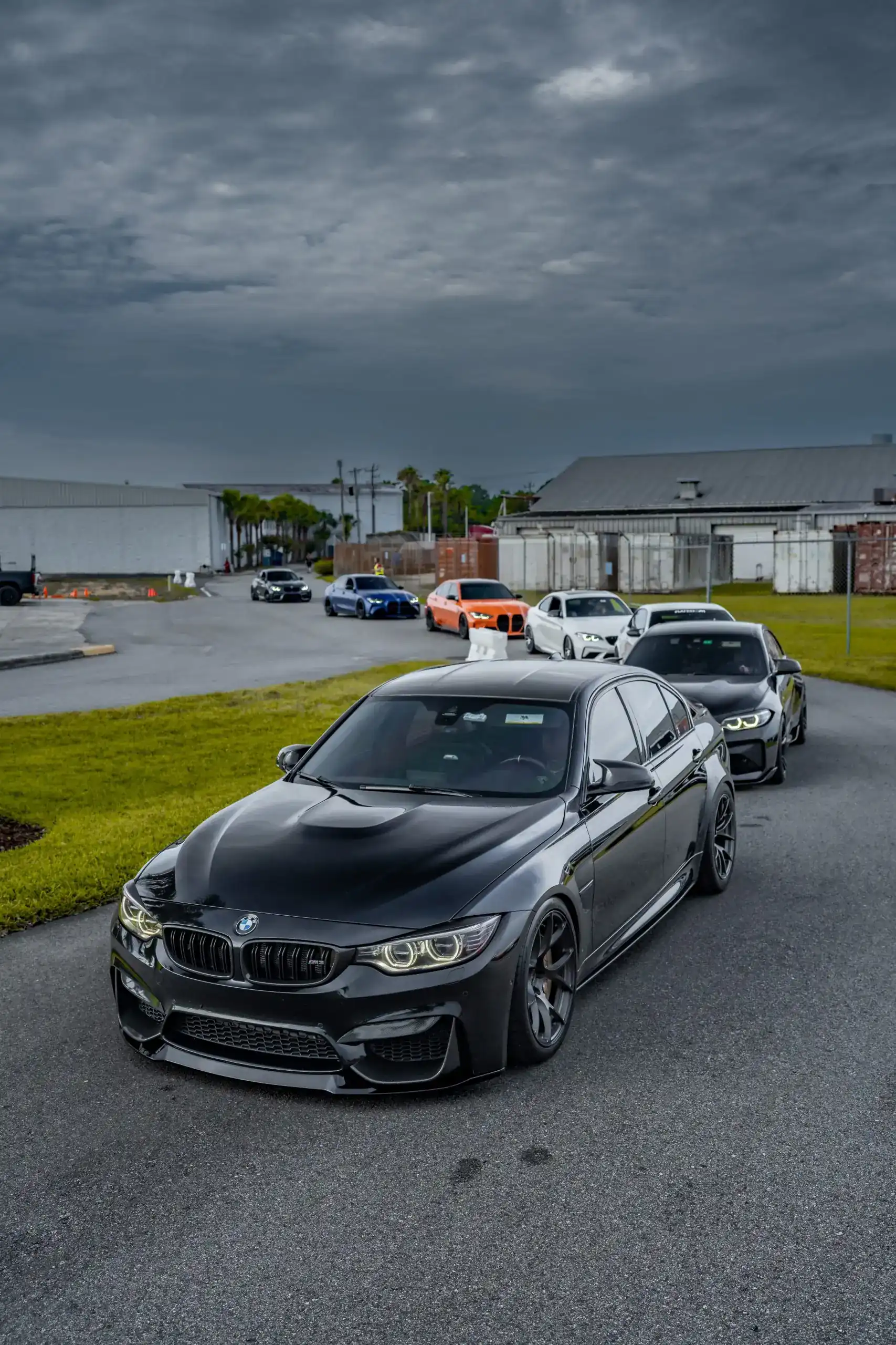 Black BMW M4 leading a line of show cars